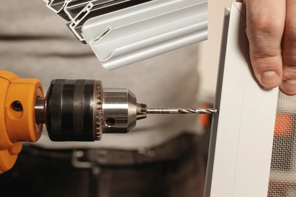 Drill being used to install a white panel into a wall. ⚙️ Get Your Aluminium Window Drilling Machine in Just 3 Steps: Add to Cart, Checkout, and Receive It at Your Workshop!